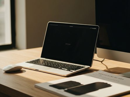 책상 위에 놓인 보험 계약서, 펜, 도장, 명함, 노트북 키보드 일부가 보이는 사무실 풍경